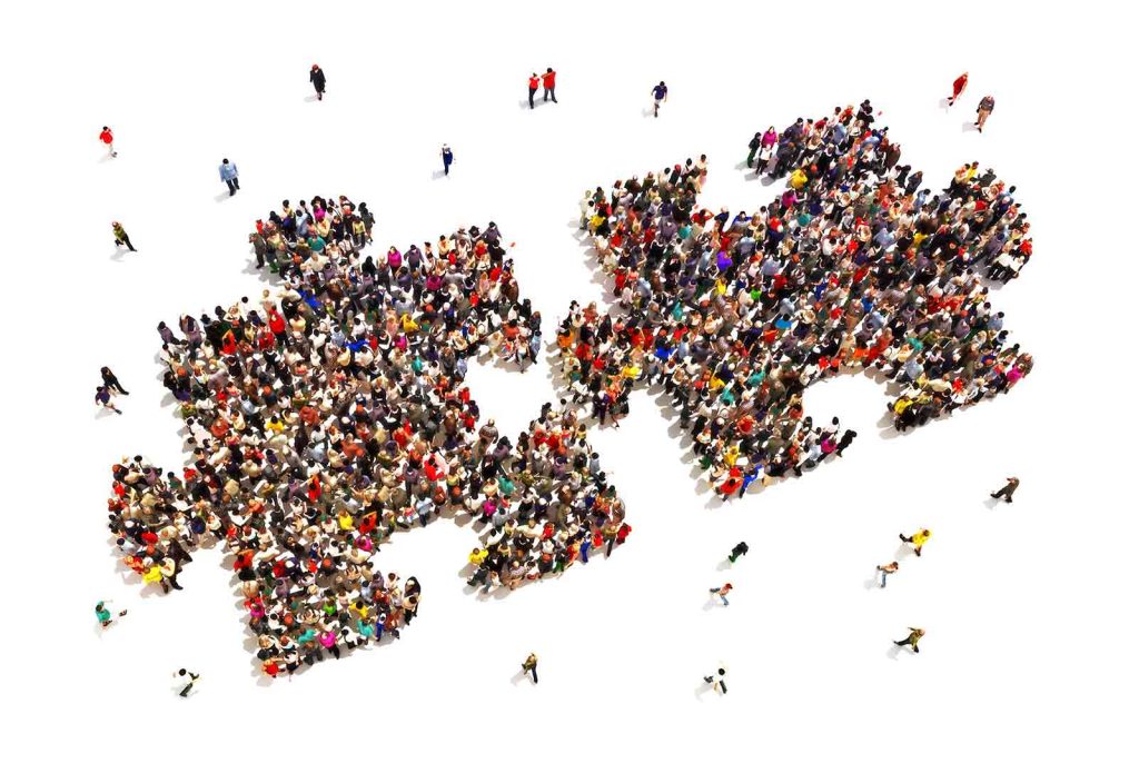Viele Menschen bilden zusammen zwei Puzzleteile